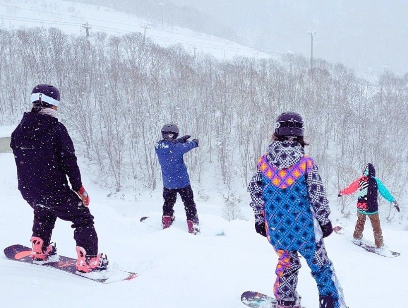 雪浪教練與朋友在二世古的粉雪坡道上滑單板